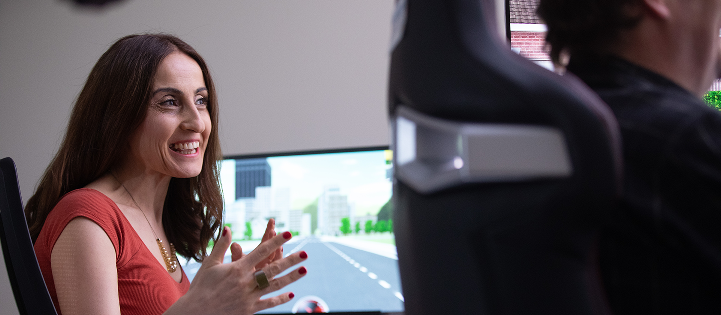 Woman talking animatedly with computer screen in the background